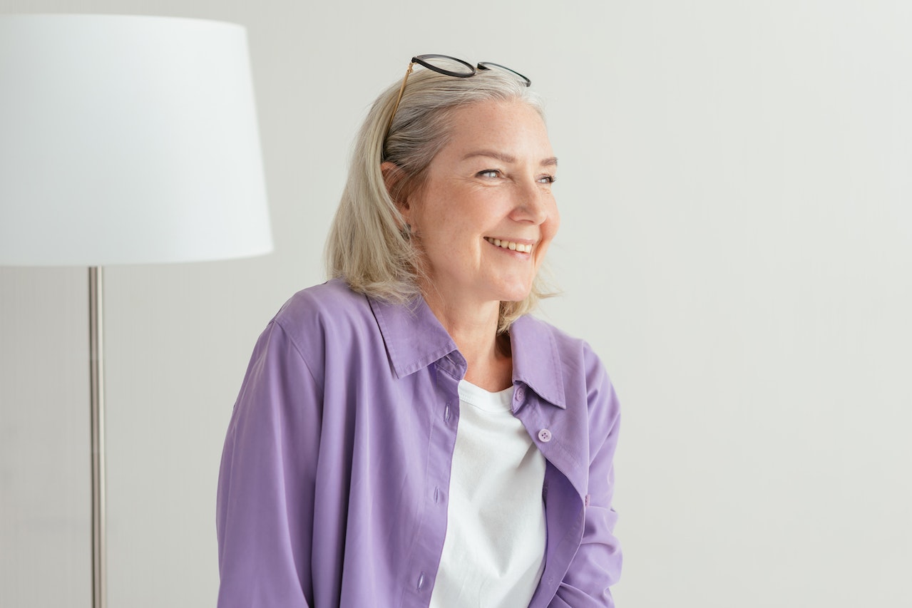 smiling older woman with implant supported dentures